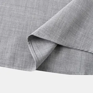 Primer plano del tejido gris con textura de lino y el dobladillo de una camisa de hombre.