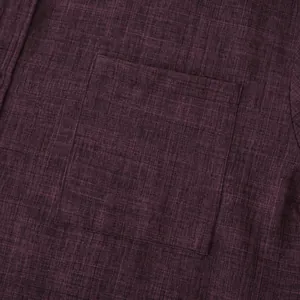 Detailed macro shot of the chest pocket on a dark burgundy men's cotton linen shirt