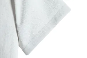 Detailed close-up showing the white textured fabric and stitching of a men's short sleeve shirt