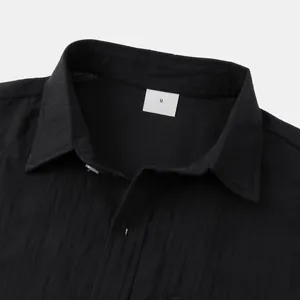 Detailed view of lapel collar and breathable cotton linen fabric on a black men's shirt