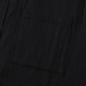 Close-up of pocket and breathable fabric texture of a black cotton linen men's shirt.