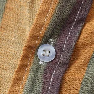 Macro close-up detail of the white button and striped cotton linen fabric on men's shirt