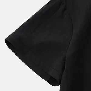 Macro close-up of solid black cotton linen men's shirt sleeve showing fabric texture.