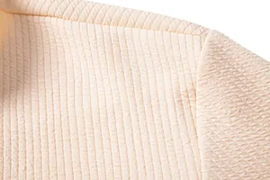 Close-up macro detail of the premium textured vertical ribbed fabric on a cream casual shirt