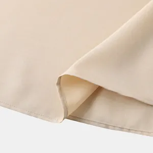 Primer plano detallado que muestra el tejido texturizado beige y la costura precisa de una camisa
