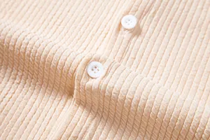 Detailed view of the ribbed fabric and white buttons on a casual beige men's shirt