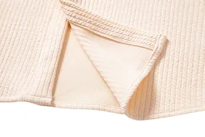 Close-up of men's cream textured shirt showing detailed hem stitching and ribbed fabric