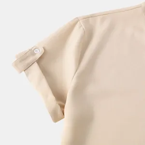 Primer plano del detalle de la manga corta de una camisa beige para hombre con botón