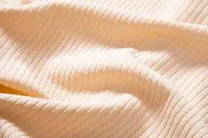 Detailed macro shot of cream ribbed fabric texture for men's casual summer shirt