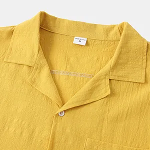 Close-up detail of yellow cotton linen shirt collar showing fabric texture and label