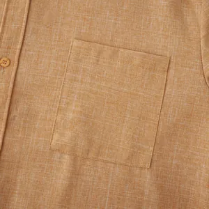 Macro detail shot showing the textured cotton linen fabric and shirt chest pocket