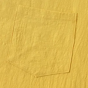 Detailed macro view of the front pocket on a yellow cotton linen casual summer shirt