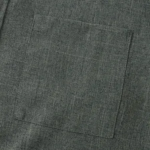 Detalle de una camisa de algodón y lino gris oscuro que muestra la costura del bolsillo.