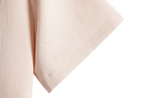 Detailed view of the textured crepe fabric and stitching on a men's beige short sleeve shirt