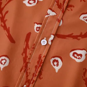 Vue rapprochée d'une chemise hawaïenne fleurie pour homme, texture orange et bouton