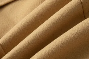 Macro close-up of camel wool fabric showing soft texture and premium quality material