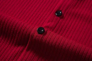 Macro detail view of red ribbed short sleeve shirt fabric with two black resin buttons.