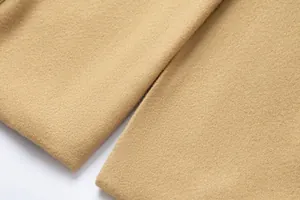 Macro view of premium camel woolen fabric showing soft texture and fine stitching details.