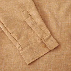 Detailed macro shot of the buttoned cuff on an orange linen blend long sleeve men's shirt
