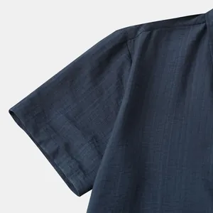 Detailweergave van de korte mouw en schoudertextuur van een marineblauw herenoverhemd