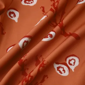 Gros plan du tissu de chemise hawaïenne orange montrant la texture et le motif floral