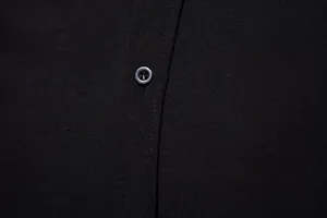Detailed macro view showing a button and the fine fabric texture of a black men's casual shirt