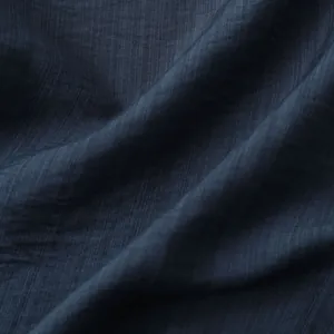 Detailopname van de ademende donkerblauwe stoftextuur voor een herenzomeroverhemd