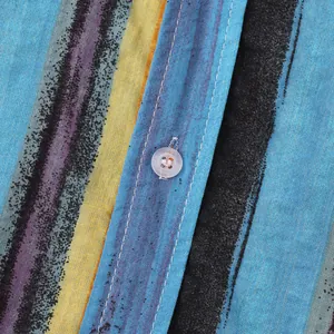 Macro detail of men's cotton linen shirt showing vibrant stripes and white button