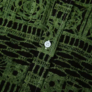 Detailopname van herenoverhemd met etnische print, stoftextuur, witte knoop en stiksels