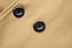 Close-up detail of black four-hole buttons on camel wool fabric of a men's trench coat.