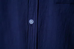Close-up view of navy blue cotton-linen shirt fabric texture and translucent button