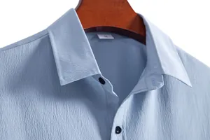 Detailed close-up of men's light blue casual shirt collar and textured fabric quality