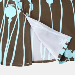 Détail du bas d'une chemise hawaïenne pour homme avec imprimé coquelicot bleu sur fond marron