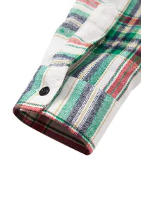 Detalle de la manga de una camisa de cuadros para hombre con diseño colorido y botón.