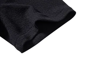 Close-up macro detail showing the black textured fabric of a men's casual shirt.