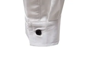 Close-up detail of white shirt cuff with black button and fine stitching details