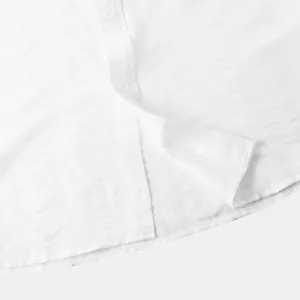 Detailopname van een wit linnen shirt met korte mouwen met focus op textuur en knopen