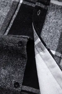 Detalle de tela de camisa de franela gruesa a cuadros con botones y textura de espiga.