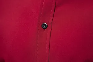 Close-up of red men's casual shirt showing fine fabric texture and black button detail