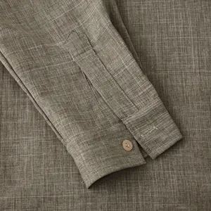 Detailed close-up of the sleeve cuff and linen fabric texture on a brown long sleeve shirt