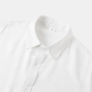 Detailopname van de kraag van een wit linnen overhemd met stoftextuur en maatlabel