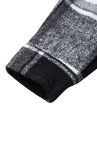 Detalle macro del puño de una camisa de cuadros grises y negros con diseño de espiga