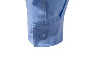 Detailed macro view of the buttoned cuff on a light blue men's cotton linen shirt