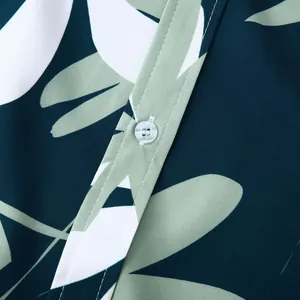 Gros plan d'une chemise hawaïenne pour hommes avec bouton blanc et motif de feuilles