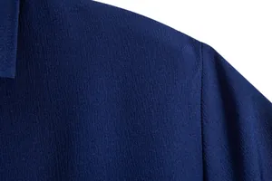 Close-up detail of the textured navy blue fabric and stitching on a men's casual shirt