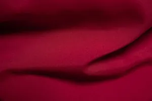 Macro shot of red solid color shirt fabric showing woven texture and soft folds