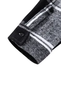Primer plano del puño de una camisa gruesa de franela gris con diseño de espiga y botón