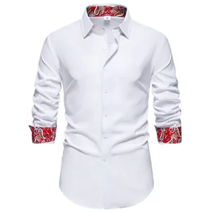 Close-up view of white long-sleeve men's shirt with elegant red paisley collar and cuff linings.