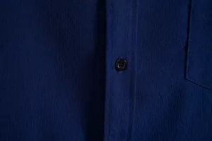 Detail of navy blue men's casual shirt showing fabric texture and button placket