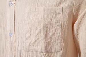 Detailed view of chest pocket and breathable cotton linen fabric on men's beige shirt